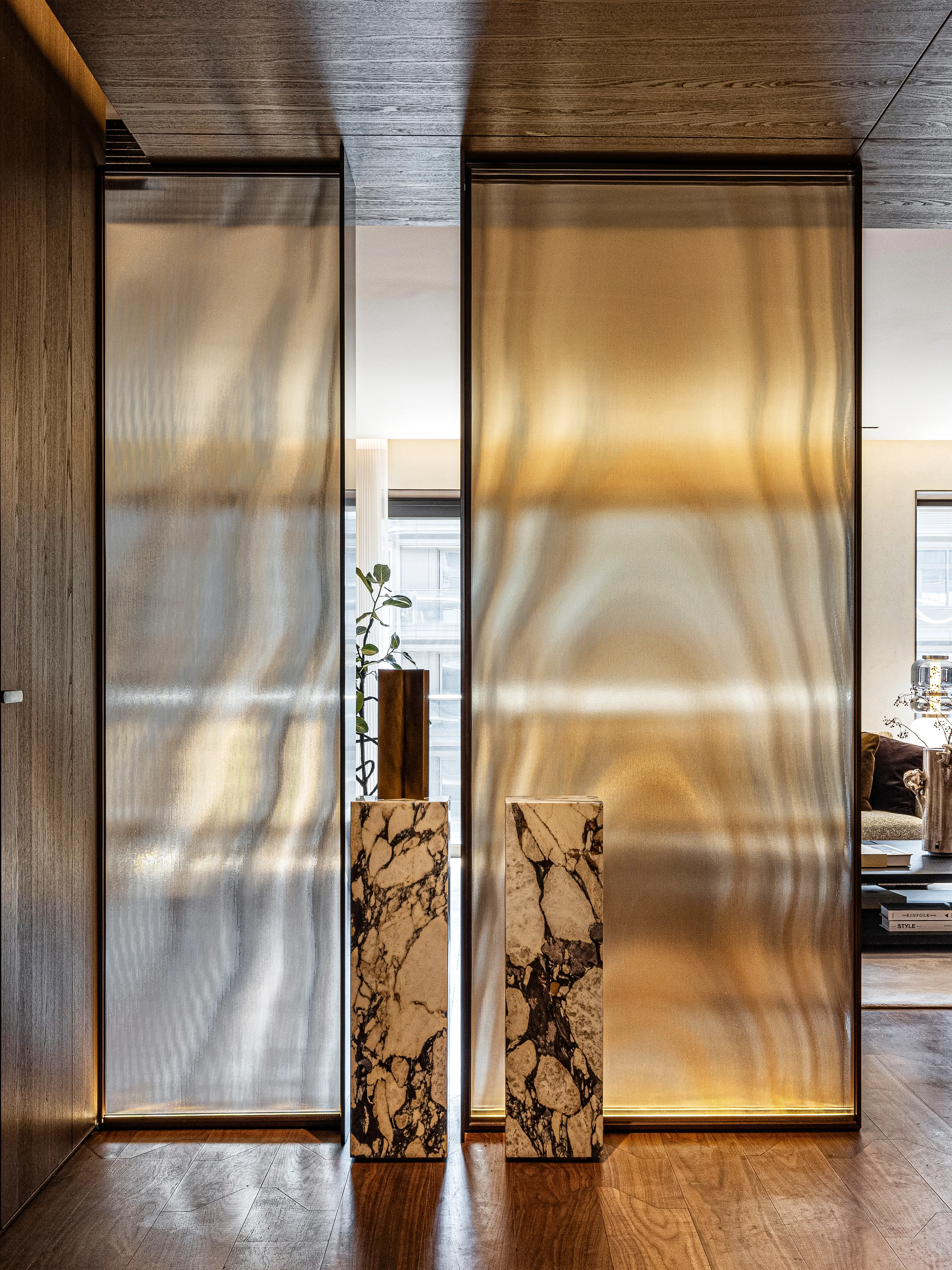 Backlit ribbed glass dividers flanked by marble pedestals, The Amber Residence, Beijing