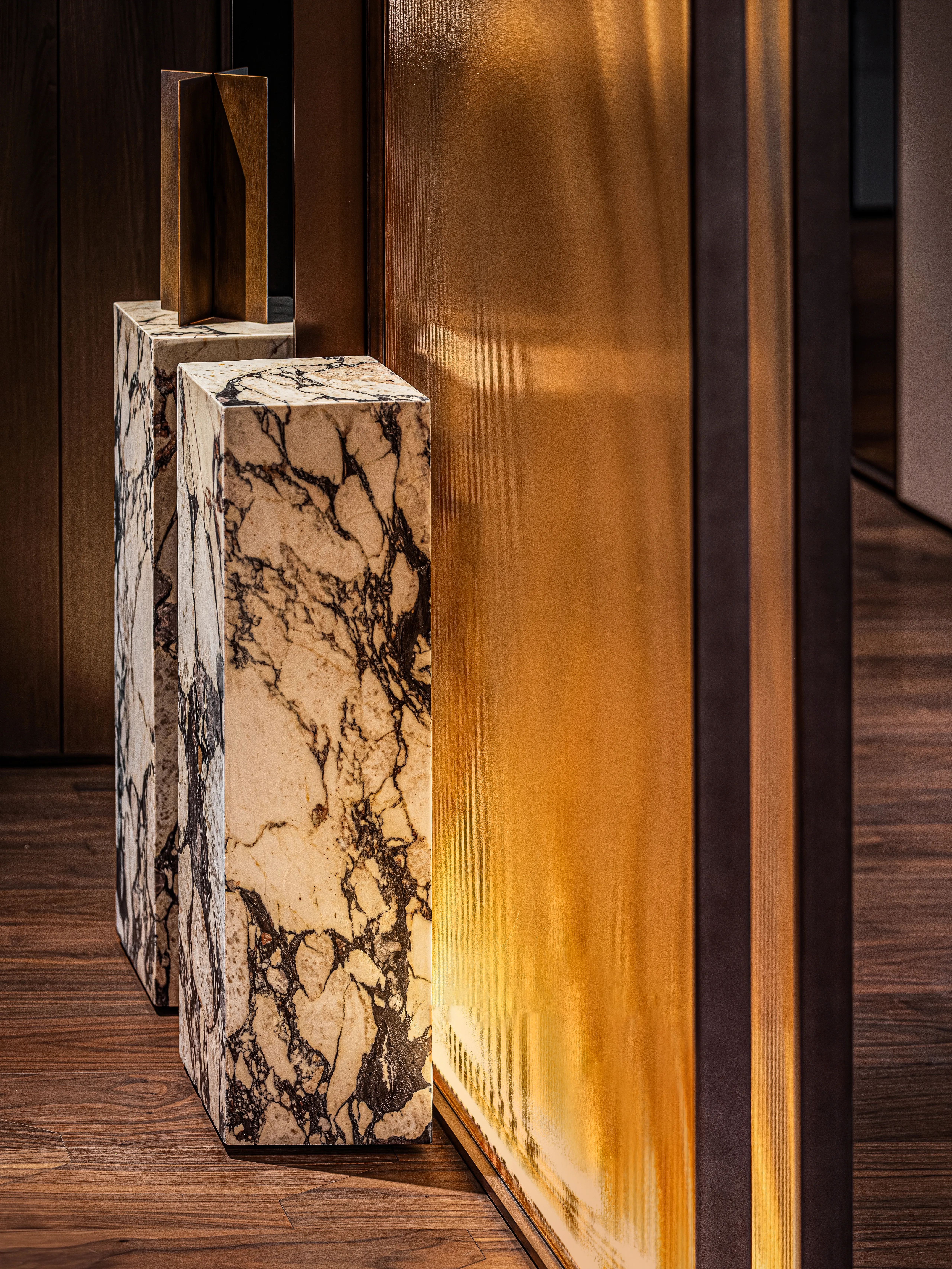 Marble pedestals beside glowing amber glass panel, The Amber Residence, Beijing