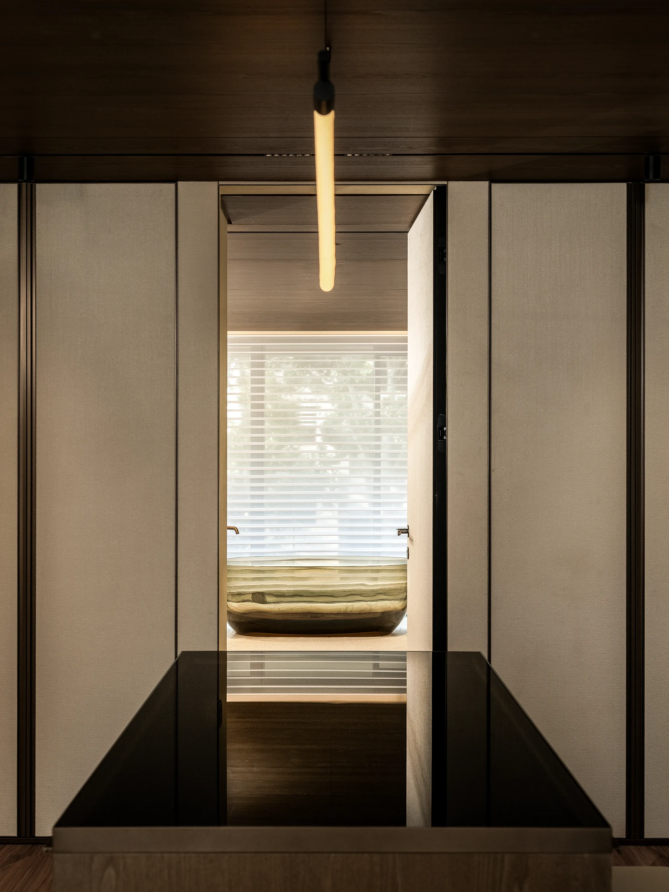 Panelled hallway view toward bedroom with pendant light and blinds, The Amber Residence, Beijing